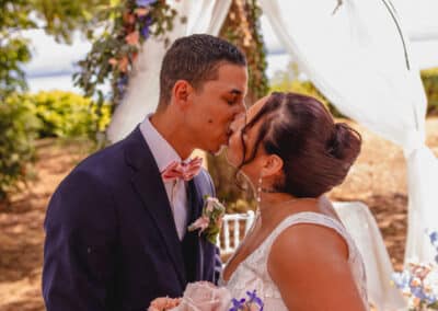 Couple de mariés échangeant un baiser lors de leur cérémonie de mariage.