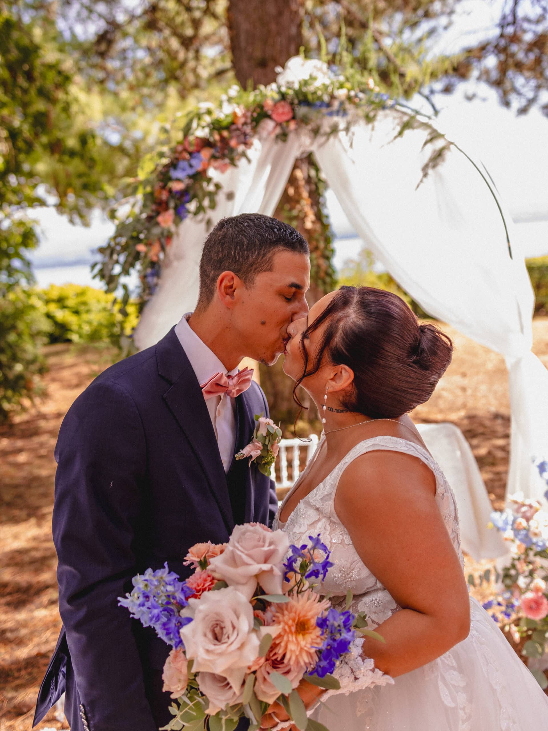 Couple de mariés échangeant un baiser lors de leur cérémonie de mariage.